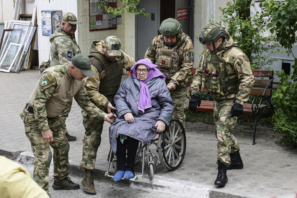 This photo released by Belgorod regional governor Vyacheslav Gladkov's Telegram channel on Sunday, May 12, 2024, volunteers help an elderly woman to leave an area of a partially collapsed block of flats after a missile attack by the Ukrainian Armed Forces in the Russian city of Belgorod, Russia.In a statement, Russia's Investigative Committee, the country's top law enforcement agency, said that the 10-story block had been hit by Ukrainian shelling. (Belgorod Region Governor Vyacheslav Gladkov Telegram channel via AP)