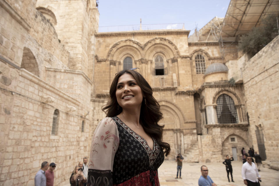 Andrea Meza, the reigning Miss Universe from Mexico, poses in front of the Church of the Holy Sepulchre as she tours the Old City of Jerusalem, Wednesday, Nov. 17, 2021, ahead of the 70th Miss Universe pageant being staged in the southern Israeli resort city of Eilat next month. She said Wednesday that the long-running beauty pageant shouldn't be politicized, even as its next edition is being held in Israel and contestants have faced pressure to drop out in solidarity with the Palestinians. (AP Photo/Maya Alleruzzo)