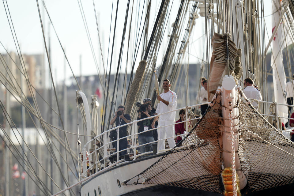 First torch bearer carrier in France French Olympic swimmer Florent Manaudou holds the Olympic torch aboard The Belem, the three-masted sailing ship in the Old port of Marseille, southern France, Wednesday, May 8, 2024. After leaving Marseille, a vast relay route is undertaken before the torch odyssey ends on July 27 in Paris. The Paris 2024 Olympic Games will run from July 26 to Aug.11, 2024. (AP Photo/Thibault Camus)