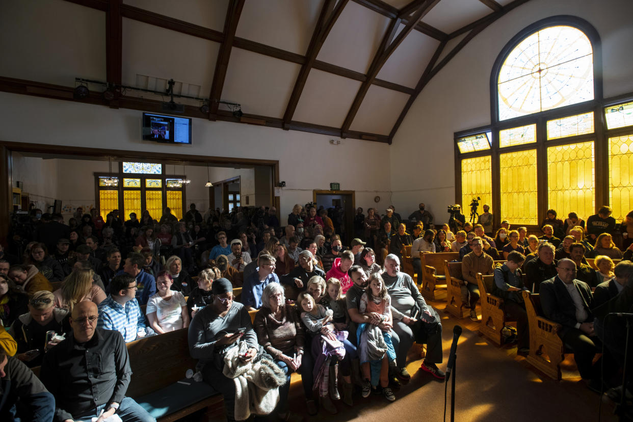 Light shines through the window of All Souls Unitarian Church illuminating community members that gathered for a service following Saturday's fatal shooting at Club Q in Colorado Springs, Colo., on Sunday, Nov. 20, 2022. (Parker Seibold/The Gazette via AP)