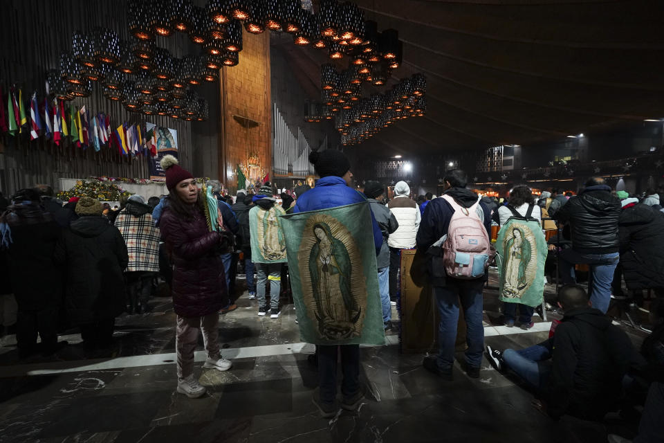 Pilgrims stand inside the Basilica of Guadalupe on her feast day in Mexico City, early Tuesday, Dec. 12, 2023. Devotees of Our Lady of Guadalupe gather for one of the world's largest religious pilgrimages on the anniversary of one of several apparitions of the Virgin Mary witnessed by an Indigenous Mexican man named Juan Diego in 1531. (AP Photo/Marco Ugarte)