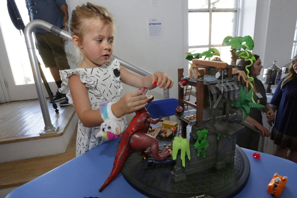 In this Aug. 30, 2018, photo Kenzie, 5, plays with the Playmobil Explorers Hidden Temple with T-Rex, at the Walmart Toy Shop event in New York. Walmart says 30 percent of its holiday toy assortment will be new. It will also offer 40 percent more toys on Walmart.com from a year ago. In November and December, the company’s toy area will be rebranded as “America’s Best Toy Shop.” (AP Photo/Richard Drew)