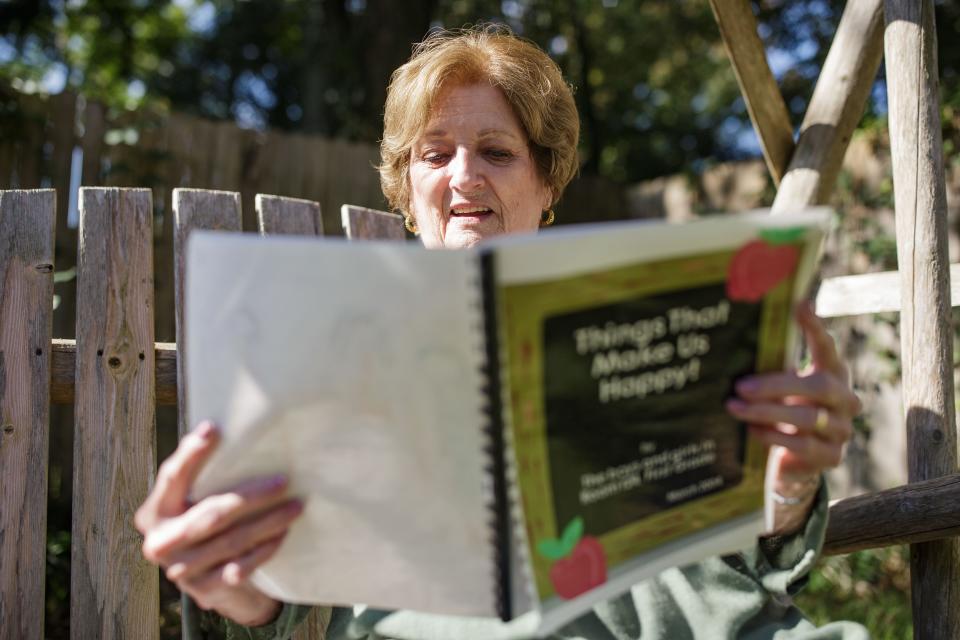 Mary Gerardi, a woman who substituted at Buck Lake Elementary for 15 years but has since stopped due to the pandemic, sits on a swing in her backyard as she flips through books she made with her students Friday, Oct. 1, 2021. 