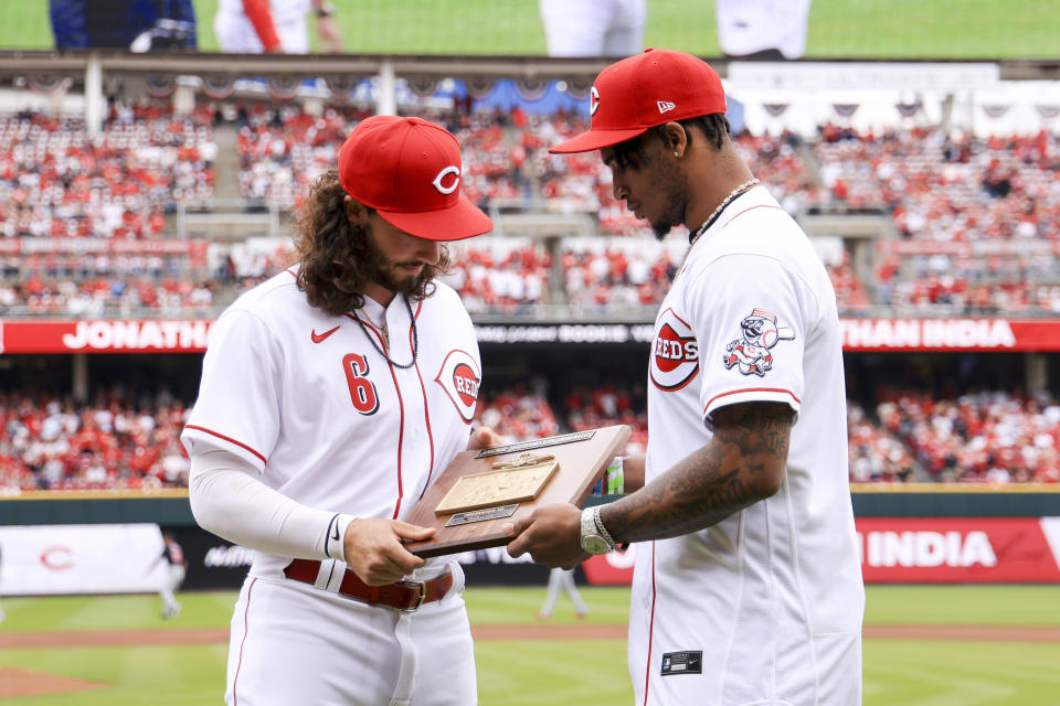 Cincinnati Reds' Jonathan India, left, receives the Major League Baseball Rookie of the Year Award presented by Cincinnati Bengals' Ja'marr Chase prior to a baseball between the Cleveland Guardians and the Cincinnati Reds in Cincinnati, Tuesday, April 12, 2022. (AP Photo/Aaron Doster)