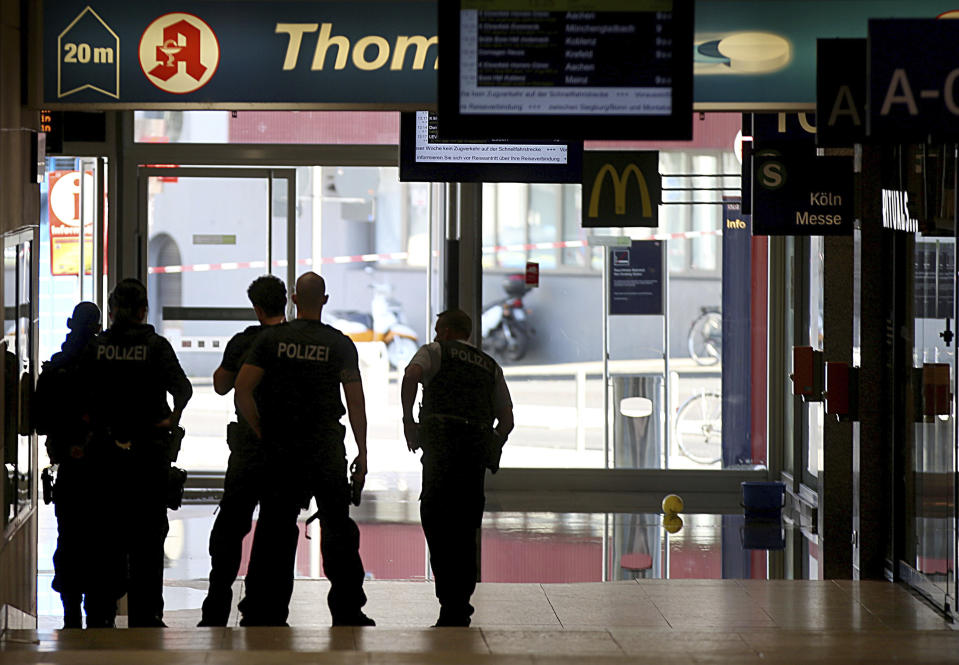 Police forces stand at the Cologne, western Germany, main station Monday, Oct. 15, 2018, after they have closed parts of the station because of a hostage situation. Police said that incident appears to have started Monday at a pharmacy inside the train station. (Oliver Berg/dpa via AP)