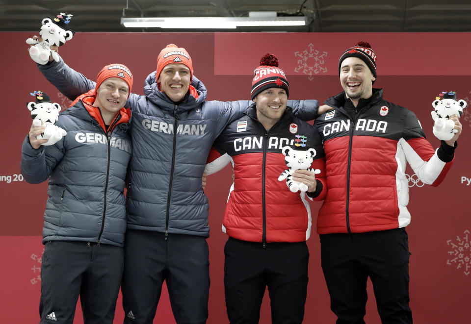 Germany and Canada celebrate their gold medals in the two-man bobsleigh in PyeongChang. (AP)