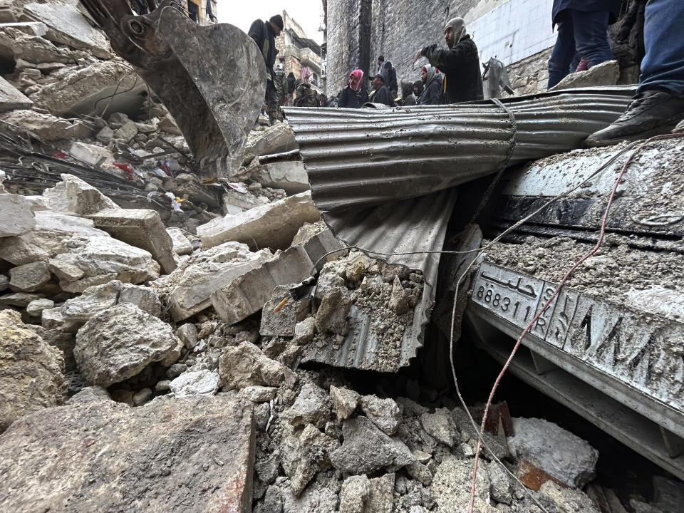 Syrian Civil Defense workers and security forces search through the wreckage of collapsed buildings, in Aleppo, Syria, Monday, Feb. 6, 2023. A powerful earthquake rocked wide swaths of Turkey and neighboring Syria on Monday, toppling hundreds of buildings and killing and injuring thousands of people. (AP Photo/Omar Sanadiki)