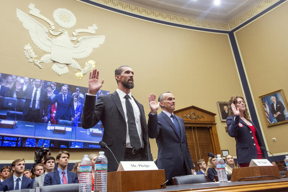 Michael Phelps, former Olympic athlete, left, Travis Tygart, Chief Executive Officer of the U.S. Anti-Doping Agency, center, and Allison Schmitt, former Olympic athlete, are sworn in during a House Committee on Energy and Commerce | Subcommittee on Oversight and Investigations examining Anti-Doping Measures in Advance of the 2024 Olympics, on Capitol Hill, Tuesday, June 25, 2024, in Washington. (AP Photo/Rod Lamkey, Jr.)