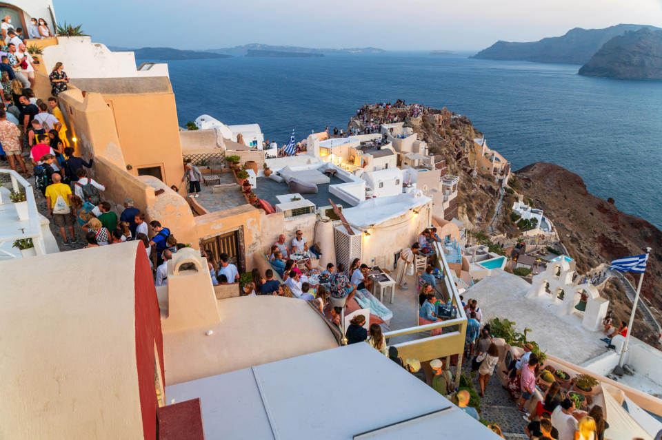 Crowd of people gathered in Santorini overlooking the sea and islands
