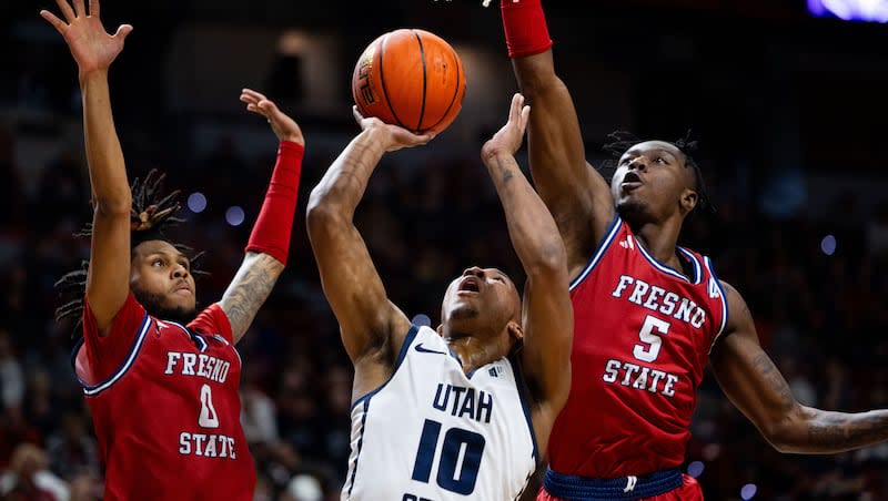 Utah State Aggies guard Darius Brown II (10) attempts a shot with Fresno State Bulldogs guard Donavan Yap Jr. (0) and Fresno State Bulldogs guard Jalen Weaver (5) on defense during the game between the Utah State Aggies and the Fresno State Bulldogs in the quarterfinals of the Mountain West 2024 Men's Basketball Tournament at the Thomas & Mack Center in Las Vegas on Thursday, March 14, 2024.