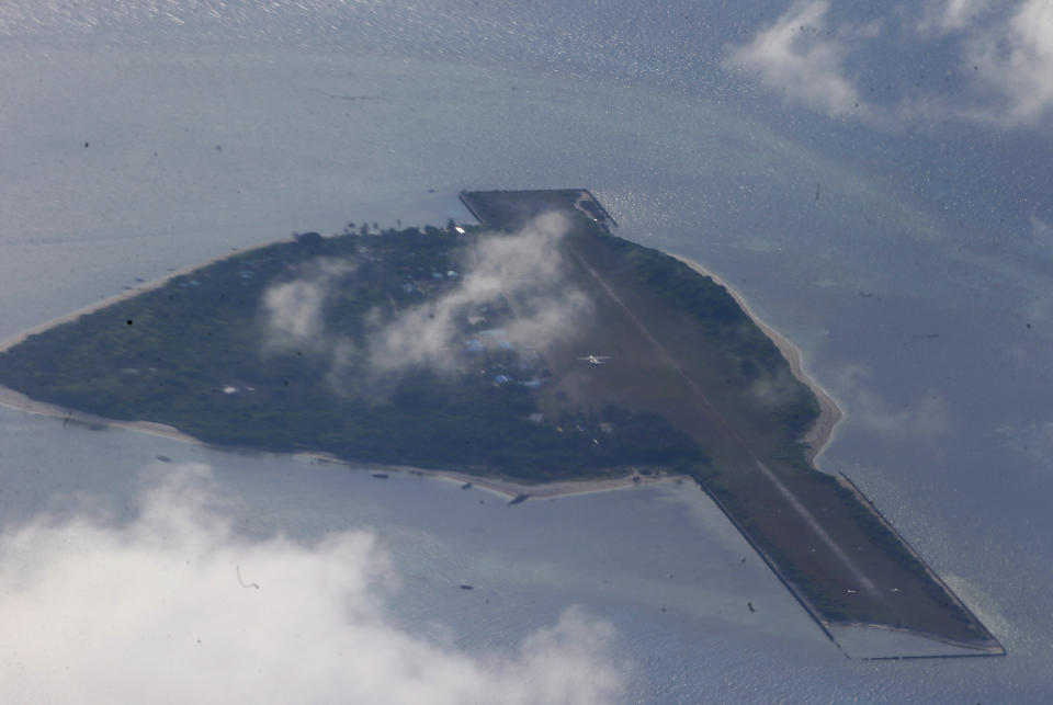 FILE - This photo taken from a C-130 transport plane with Defense Chief Delfin Lorenzana and Armed Forces Chief Gen. Eduardo Ano shows Thitu Island off the South China Sea on April 21, 2017. A Chinese coast guard vessel twice blocked the Philippine naval boat before seizing the debris it was towing Sunday off Philippine-occupied Thitu Island, Vice Admiral Alberto Carlos said Monday., Nov. 21, 2022. (AP Photo/Bullit Marquez, File)