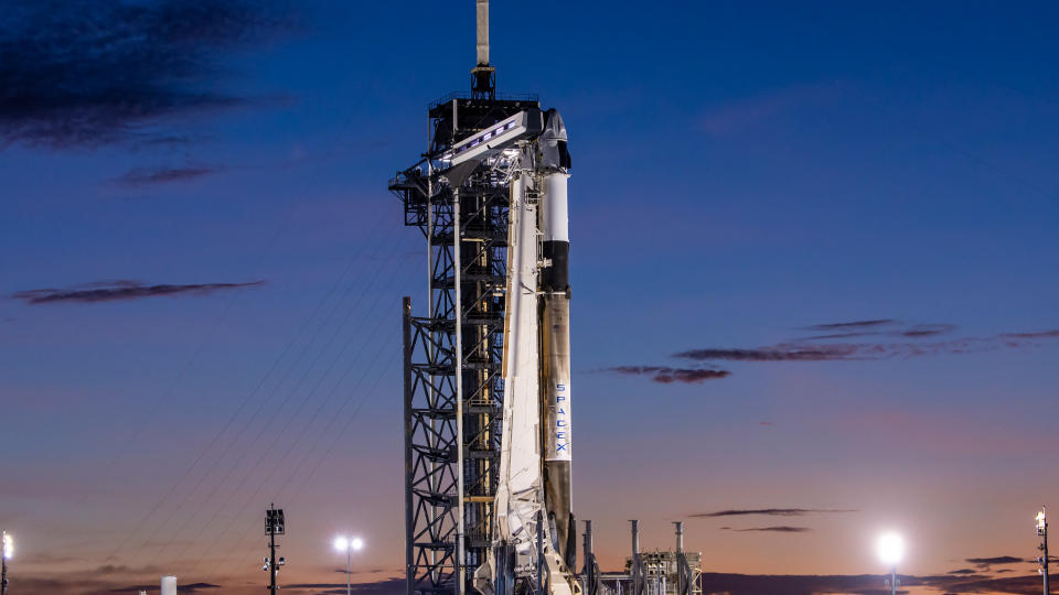 a white rocket with a white cone-shaped spacecraft on top