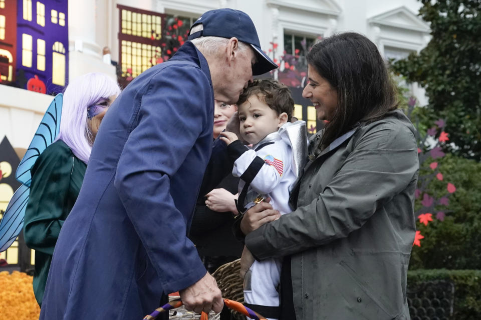President Joe Biden gives a kiss on the forehead to a young child as he and first lady Jill Biden give treats to trick-or-treaters on the South Lawn of the White House, on Halloween, Monday, Oct. 31, 2022, in Washington. (AP Photo/Alex Brandon)