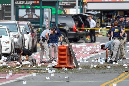 Federal Bureau of Investigation (FBI) and other security officials mark evidence near the site of an explosion which took place on Saturday night in the Chelsea neighborhood of Manhattan, New York, U.S. September 18, 2016. REUTERS/Rashid Umar Abbasi