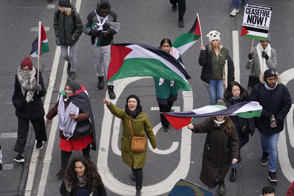 Protesters hold up banners, flags and placards as they walk along the embankment by the River Thames during a demonstration in support of Palestinian people in Gaza, in London, Saturday, Jan. 13, 2024.(AP Photo/Alberto Pezzali)