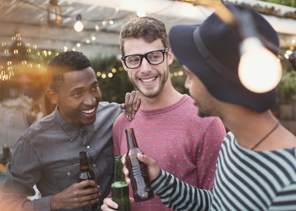 Three men enjoy beers together