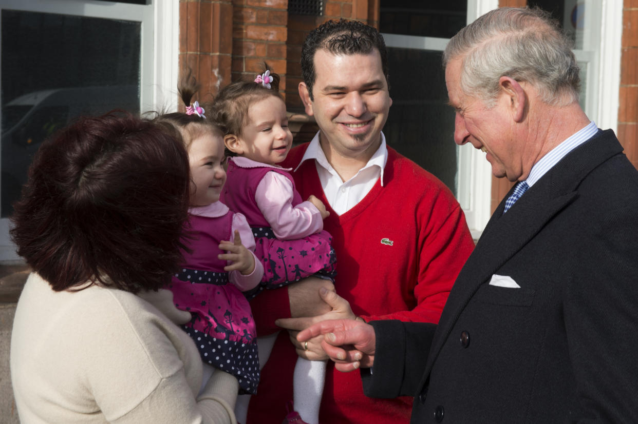 LONDON, ENGLAND - FEBRUARY 5: Prince Charles, Prince of Wales speaks to husband and wife Mehmet and Burcin Akbasak with their twin daughters 12-month-old Kayla and Lara, whose flat above the Carpetright building was destroyed in the riots as the Prince visits Tottenham on February 5, 2014 in London, England. (Photo by Paul Edwards-WPA Pool/Getty Images)