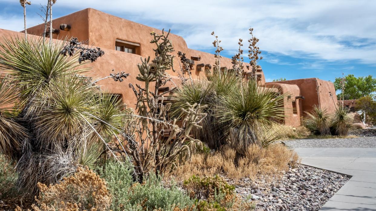 New Mexico, USA - April 24, 2006 : Mexican hacienda in adobe behind the cactus in New Mexico, USA.