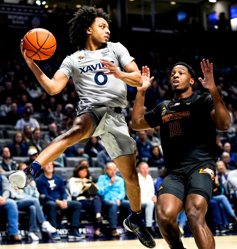 Xavier Musketeers guard Trey Green (0) slings the ball to pass it midair in the first half of the NCAA basketball game between the Winthrop Eagles and Xavier Musketeers on Saturday, Dec. 16, 2023, at the Cintas Center in Cincinnati.