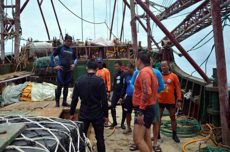 Photo released on April 10, 2013 shows Philippine Coast Guard personnel inspecting the Chinese fishing vessel that ran aground off Tubbataha reef in Palawan island, western Philippines