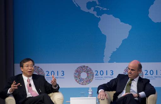 Yi Gang (L), Deputy Governor of the People's Bank of China, speaks alongside Luis de Guindos, Minister of Economy and Competitiveness of Spain, during a CNN Debate on the Global Economy at George Washington University on October 10, 2013