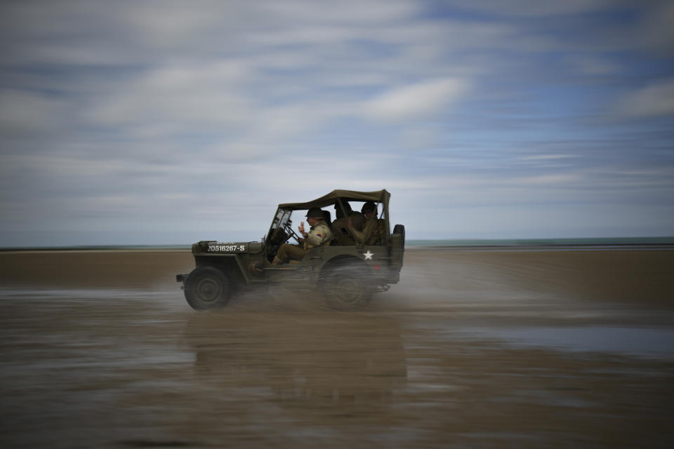 Reenactors drive a vintage US Army jeep along Utah Beach near Sainte-Marie-du-Mont, Normandy, France, Tuesday, June 4, 2024. World War II veterans from across the United States as well as Britain and Canada are in Normandy this week to mark 80 years since the D-Day landings that helped lead to Hitler's defeat. (AP Photo/Daniel Cole)