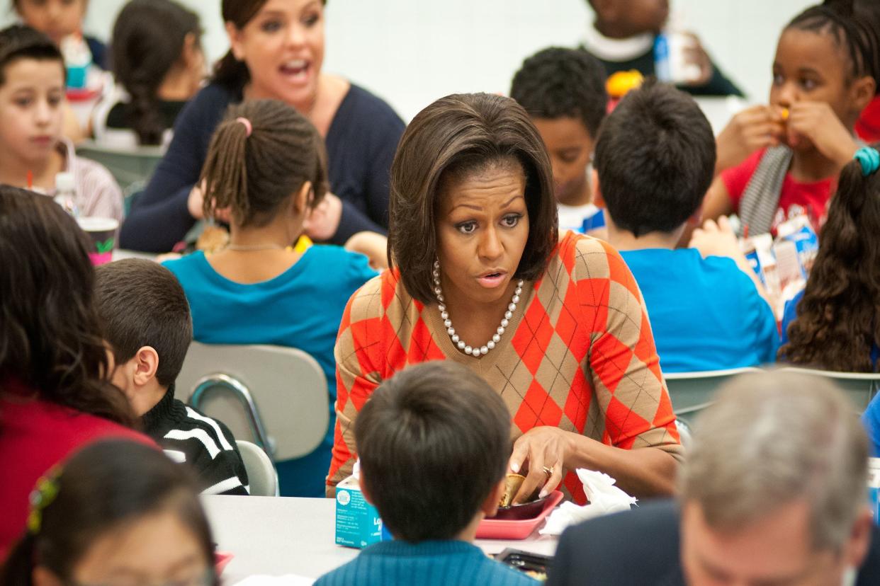 Michelle Obama sitting at a school lunch table