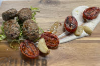 Believer Meats Research and Development Chef Andres Voloschin diplays a dish made from the company's cultivated lamb product at a test kitchen in Rehovot, Israel on Feb. 13, 2023. Believer is one of a growing number of companies making cultivated meat, which can be produced without raising and killing animals. (AP Photo/Laura Ungar)