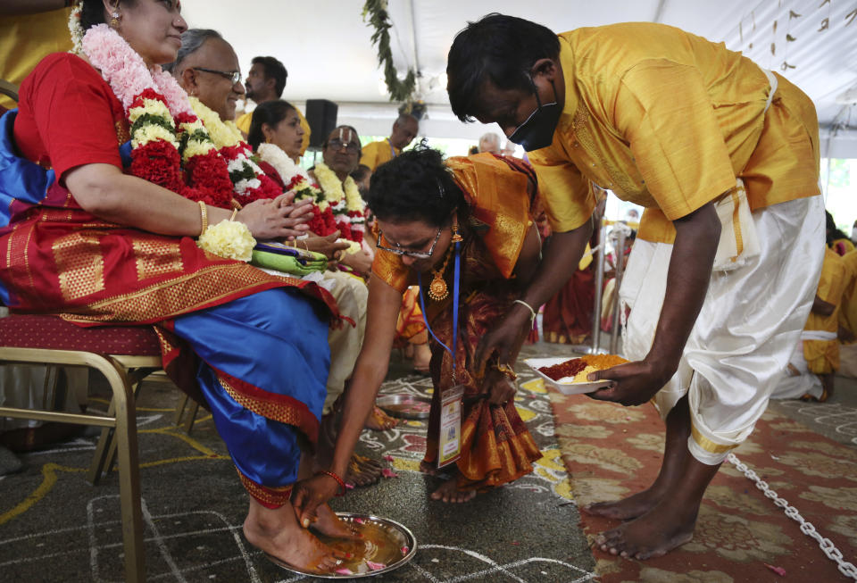 Latha Varadajan, left, has her feet washed by Sudha Krishnasamy, center, during Maha Kumbhabhishekam, a five-day rededication ceremony at the Sri Venkateswara Temple in Penn Hills, Pa., Sunday, June 27, 2021. (AP Photo/Jessie Wardarski)