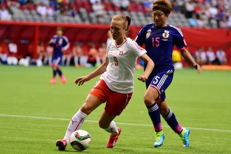 Jun 8, 2015; Vancouver, British Columbia, CAN; Switzerland midfielder Lia Waelti (9) kicks the ball in front of Japan forward Yuika Sugasawa (15) during the second half in a Group C soccer match in the 2015 women's World Cup at BC Place Stadium. Mandatory Credit: Anne-Marie Sorvin-USA TODAY Sports