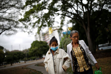 Yasmira Castano (L), 40, who lost her transplanted kidney, walks helped by her mother after she received a dialysis session at a state hospital in Caracas, Venezuela February 14, 2018. REUTERS/Carlos Garcia Rawlins