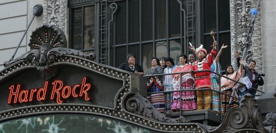 Members of the Seminole tribe waving from atop the marquee of the Hard Rock cafe