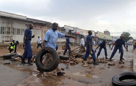 Burundi policemen clear a barricade set up by protestors opposing President Pierre Nkurunziza from running for a third term, in the capital Bujumbura, April 17, 2015. REUTERS/Jean Pierre Aime Harerimana