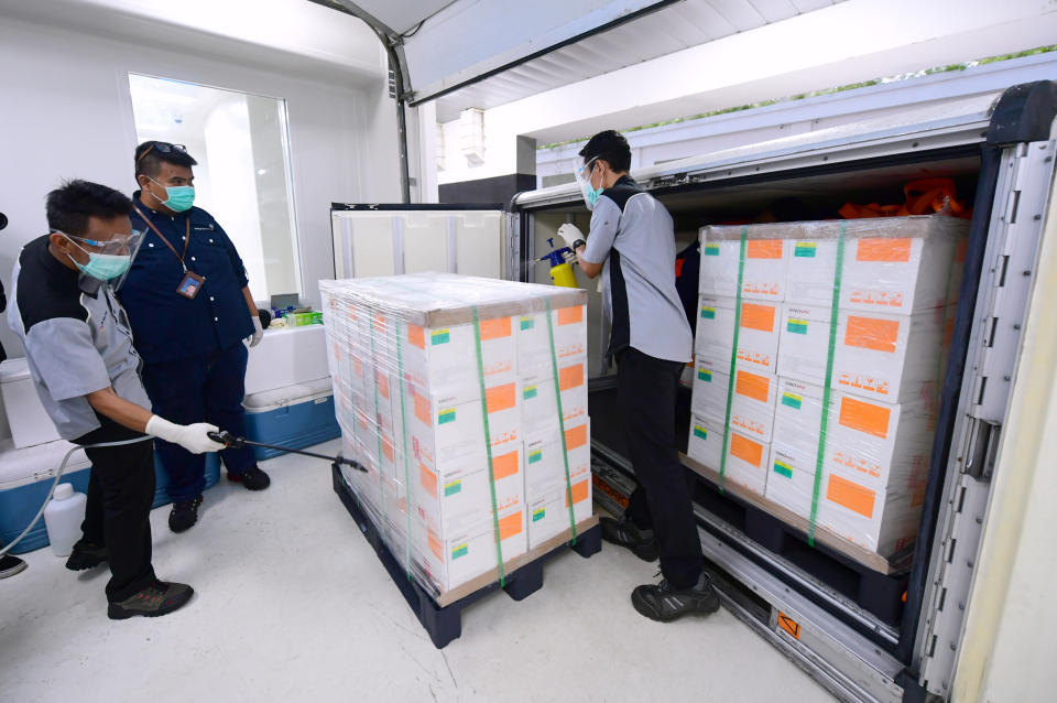 FILE - In this Dec. 7, 2020, file photo, released by Indonesian Presidential Palace, workers spray disinfectant on boxes containing experimental coronavirus vaccines made by Chinese company Sinovac arriving at a facility of state-owned pharmaceutical company Bio Farma, in Bandung, West Java, Indonesia. With rich countries snapping up supplies of COVID-19 vaccines, some parts of the world may have to rely on Chinese-developed shots to conquer the outbreak. The question: Will they work? (Indonesian Presidential Palace via AP, File)