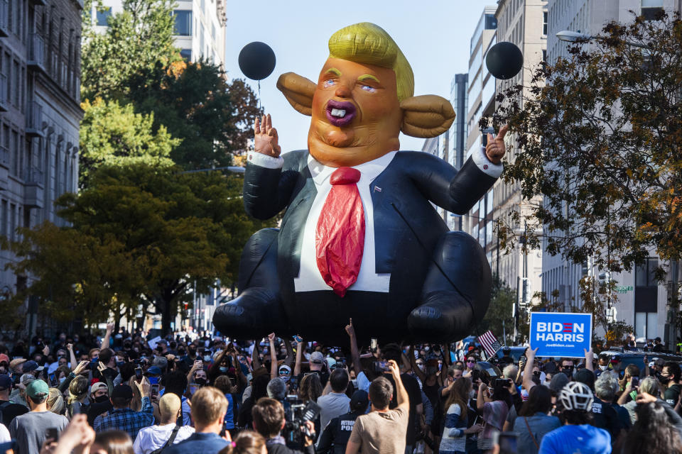 A ballon depicting a caricature of Donald Trump is carried by revelers in Washington, D.C. to celebrate Joe Biden becoming the 46th president of the United States. (Photo By Tom Williams/CQ Roll Call)