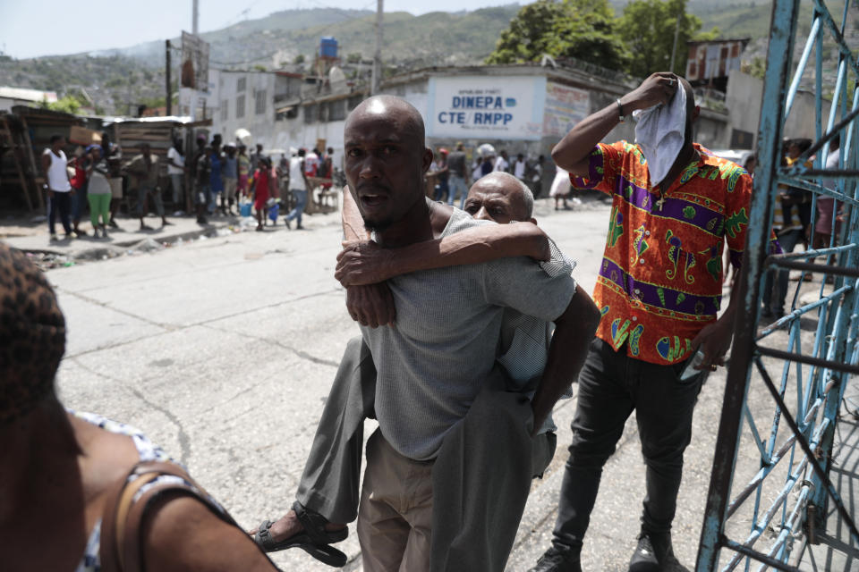 An elderly man is carried as residents flee their homes to avoid clashes between armed gangs in the Carrefour-Feuilles district of Port-au-Prince, Haiti, Tuesday, Aug. 15, 2023. (AP Photo/Odelyn Joseph)