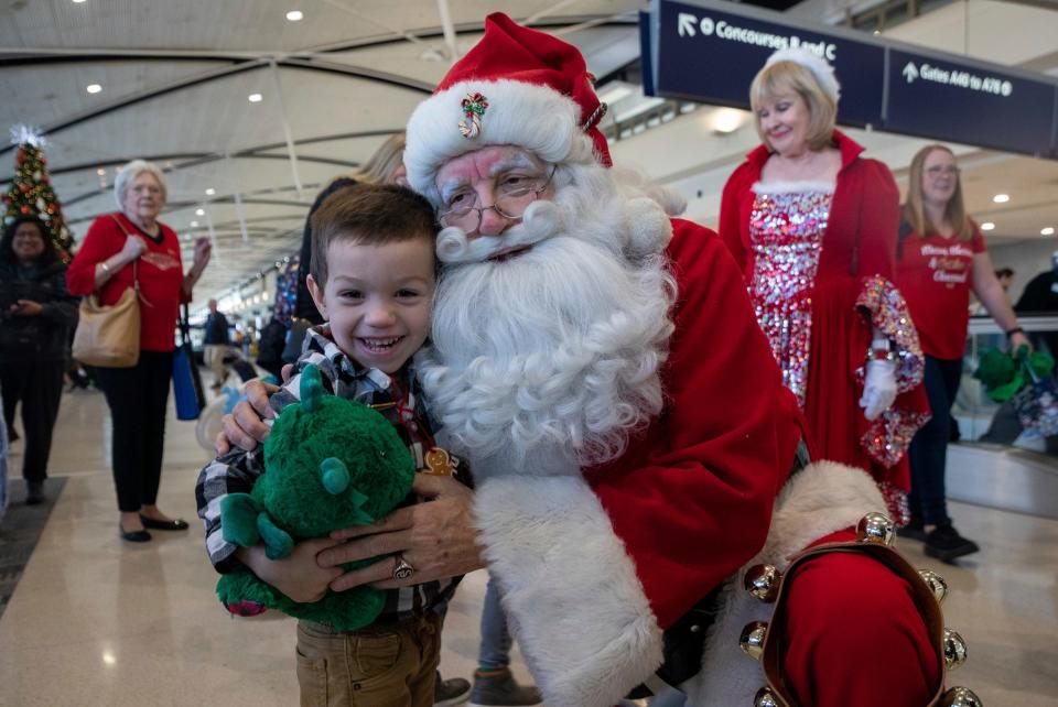 Four-year-old Jack Smith hugs Santa Claus, portrayed by Bill Neelsen, during the Flight to the North Pole event at the Detroit Metropolitan Airport on Tuesday, Dec. 12, 2023.