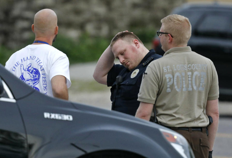 Police officers react in front of Clay's Wellston Food Market Restaurant in Wellston, Mo., on Sunday, June 23, 2019, after word came that a fellow officer had died after being shot inside the market in Wellston. (J.B. Forbes//St. Louis Post-Dispatch via AP)