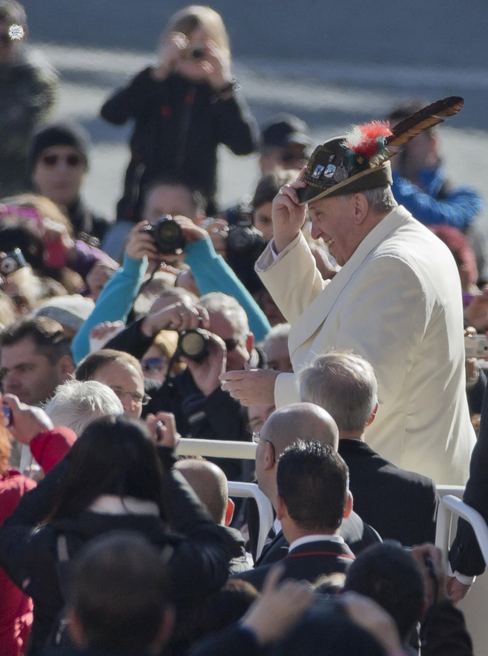 Pope Francis wears an Italian Alpine troops hat he was offered while touring St. Peter's Square at the Vatican prior to the start of his weekly general audience, Wednesday, March 5, 2014. The pontiff says he finds the hype that is increasingly surrounding him "offensive." In an interview with Italian daily Corriere della Sera, Francis said he doesn't appreciate the myth-making that has seen him depicted as a "Superpope" who sneaks out at night to feed the poor. On Wednesday, a new Italian weekly hit newsstands — a gossip magazine devoted entirely to the pope. Francis said: "The pope is a man who laughs, cries, sleeps calmly and has friends like everyone else. A normal person." (AP Photo/Alessandra Tarantino)