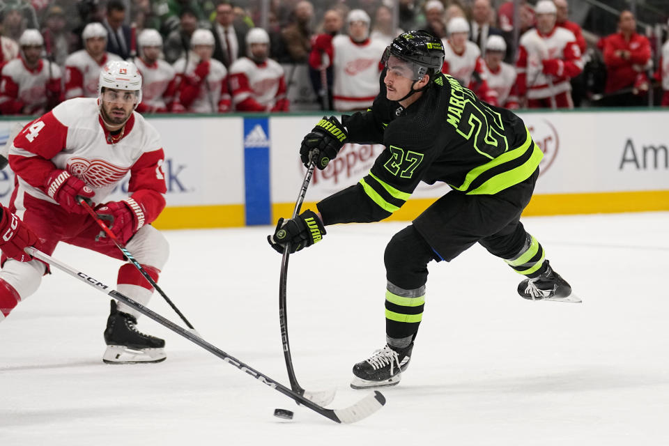 Dallas Stars left wing Mason Marchment (27) shoots as Detroit Red Wings center Robby Fabbri (14) watches in the first period of an NHL hockey game in Dallas, Monday, Dec. 11, 2023. (AP Photo/Tony Gutierrez)