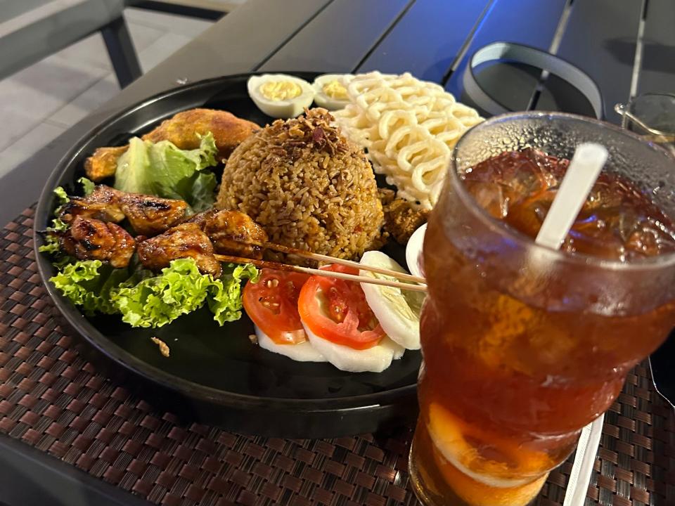 A plate of nasi goreng and a cup of iced tea