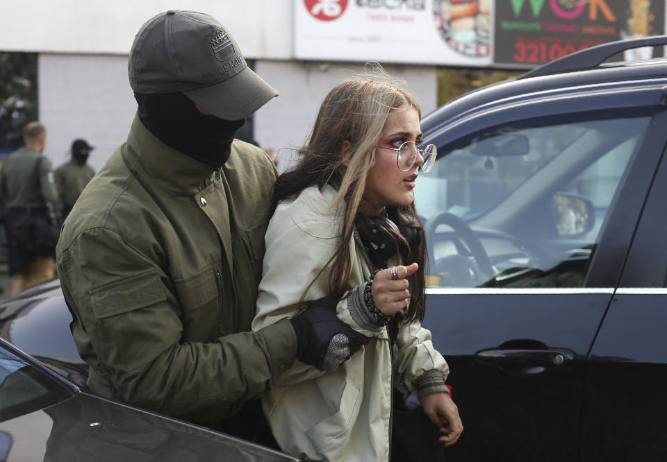 Police officer detains a woman during an opposition rally to protest the official presidential election results in Minsk, Belarus, Saturday, Sept. 19, 2020. Daily protests calling for the authoritarian president's resignation are now in their second month and opposition determination appears strong despite the detention of protest leaders. (AP Photo/TUT.by)