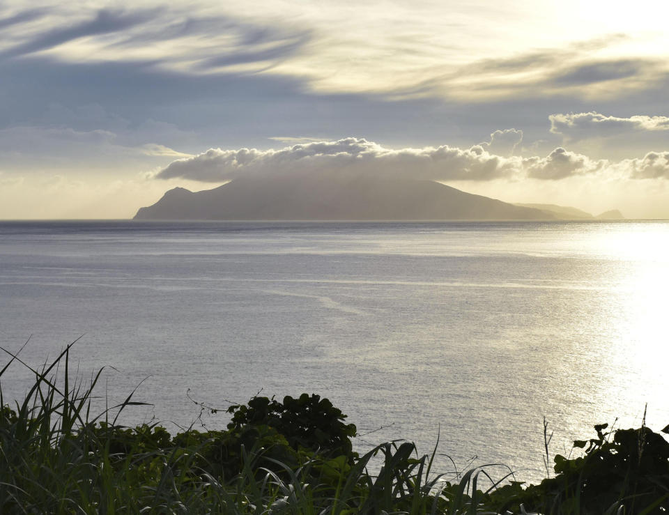 Kuchinoerabu island, background, is pictured from Yaku island in Kagoshima, southern Japan Wednesday, Aug. 15, 2018. Japan raised alert levels on the small southern volcanic island on Wednesday, urging its 105 residents to prepare for an evacuation amid growing risks of an eruption. (Kyodo News via AP)