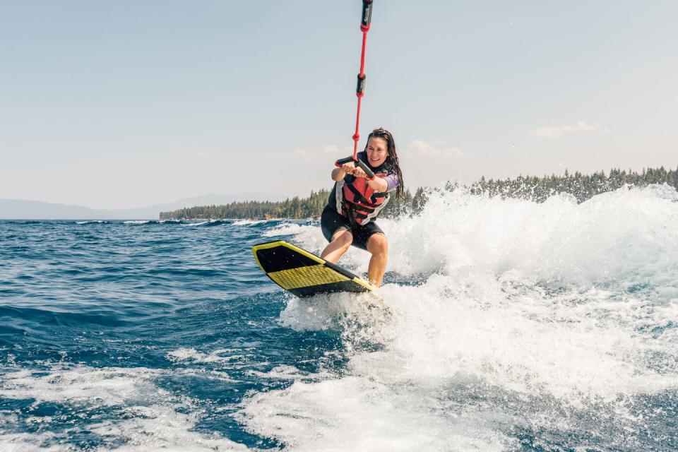 woman wakeboarding at lake