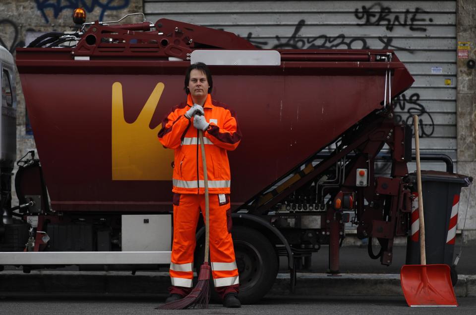 Francesco Foglia, 37, poses for a picture as he works as a street sweeper in downtown Rome