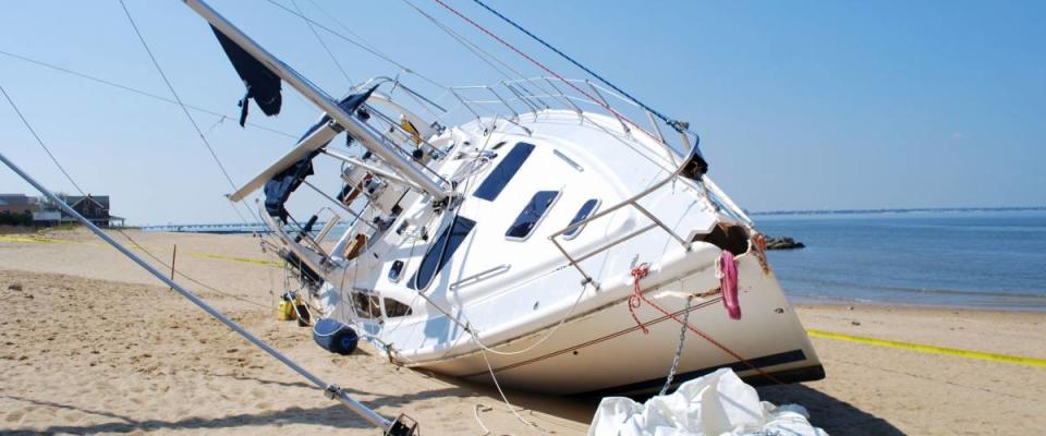 NORFOLK, VIRGINIA - AUG 28: A sailboat lies damaged on the beach on August 28, 2011 in Norfolk, Virginia a day after Hurricane Irene hit the area on Aug. 27, 2011.