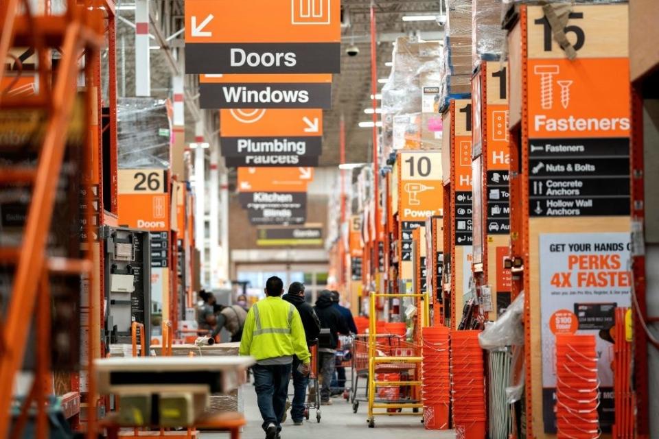 People walking through an aisle of a hardware store