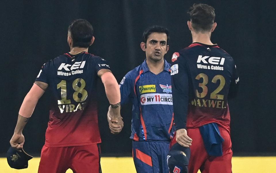 Lucknow Super Giants’ team mentor Gautam Gambhir (centre) shakes hands with Royal Challengers Bangalore’s Virat Kohli (left) and Glenn Maxwell (right) at the end of the Indian Premier League (IPL) Twenty20 cricket match between Lucknow Super Giants and Royal Challengers Bangalore (AFP via Getty Images)