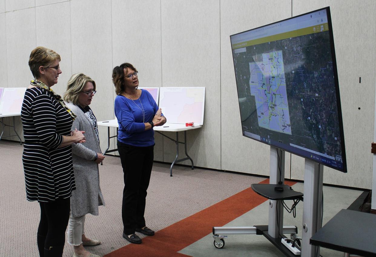 Washington Township Board member Tammy Parker, left, Morgan County Treasurer Terry Clelland and Morgan County Clerk Stephanie Elliott look over maps presented at Thursday's open house meeting.