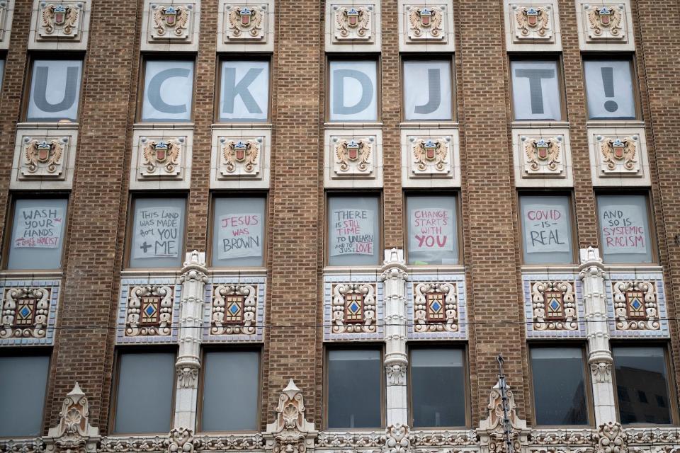 Signs critical of President Donald Trump's rally are seen in a building above an entrance point for Saturday's rally, on June 19, 2020.